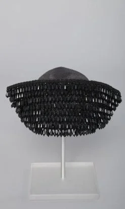 Chapeau en paille noire recouverte de perles noires sur la bordure