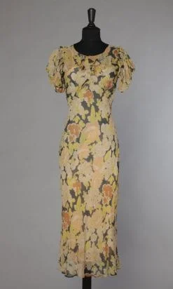 Robe 1930 en mousseline de soie imprimée de fleurs jaunes et orangées fond noir