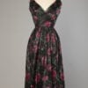 Robe 1950 en taffetas de soie noir imprimée de fleurs rouges et roses